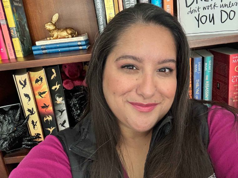 Erica Carrasco taking a selfie in front of her book case